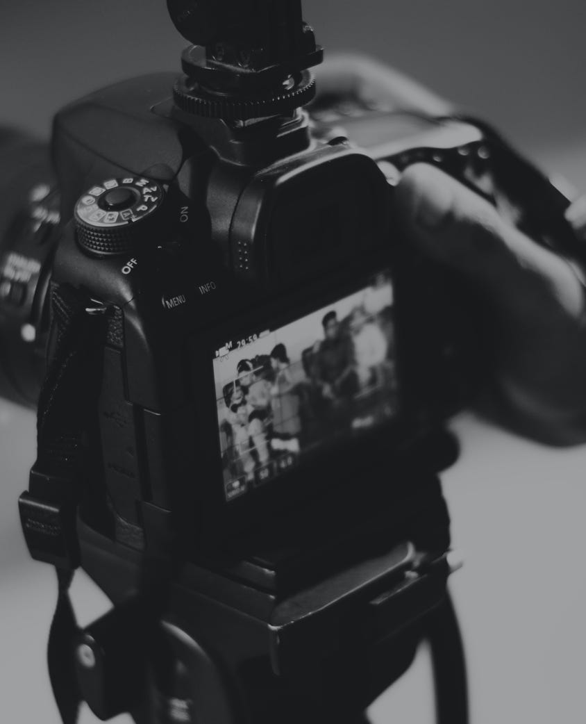 Grayscale Photography of Person Holding Black Dslr Camera